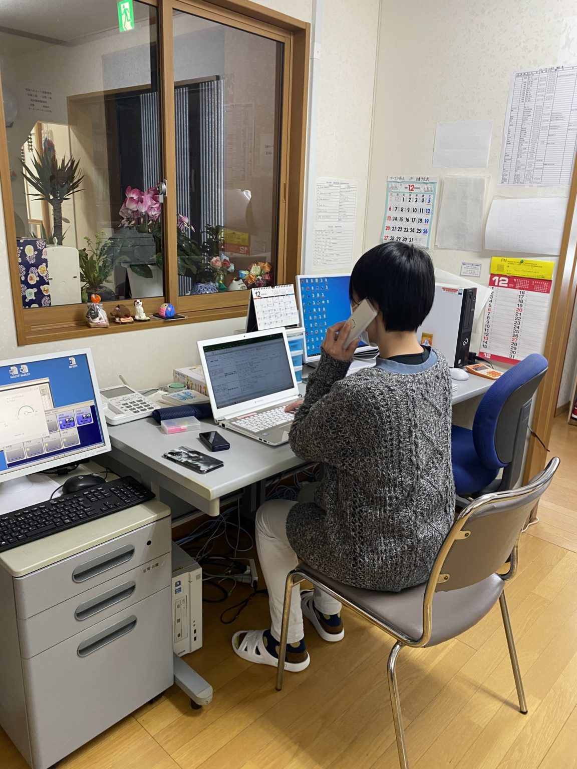 介護施設のスタッフが受付・事務所でパソコン作業をしている風景